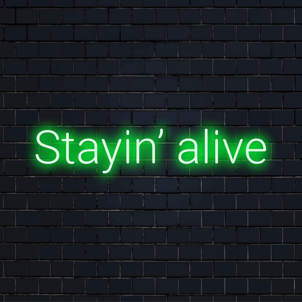 Mittatilaustyönä valmistettu LED-valokyltti, jossa on ikoninen lause Stayin' Alive, sopii täydellisesti eloisaan kodin tai toimiston neonsisustukseen.