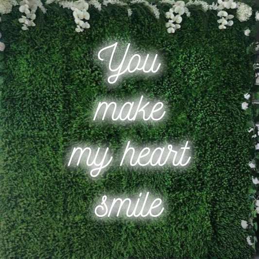 Säteilevä neonkyltti "You Make My Heart Smile" -tekstillä, täydellinen lisäämään viehätysvoimaa ja lämpöä mihin tahansa tilaan. Mukautettu LED-suunnittelu.