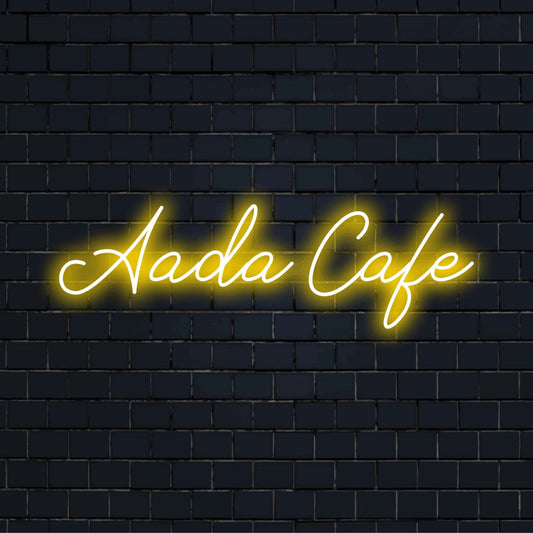 Aada Cafe Personalized LED Neon Sign, glowing neon text on dark brick wall