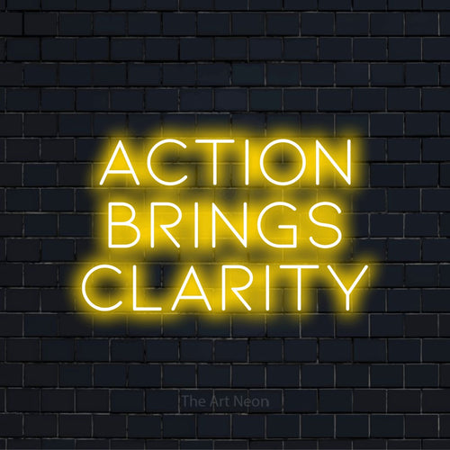 "Action Brings Clarity" script-style LED neon sign on a black brick wall