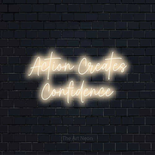 "Action Creates Confidence" LED neon sign on a black brick wall
