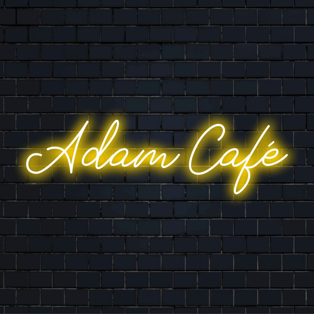 Adam Cafe Custom Name Neon Sign, glowing lettering on dark brick wall