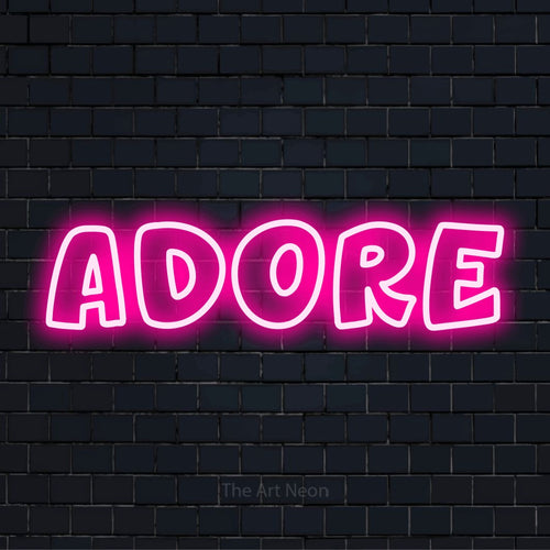 "Adore" neon text design on a black brick wall