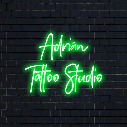 Adrian Tattoo Studio Custom Name Neon Sign, glowing neon text on black brick background
