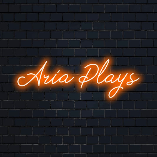 Aria Plays Custom Name Neon Sign, bright neon lettering on dark brick background