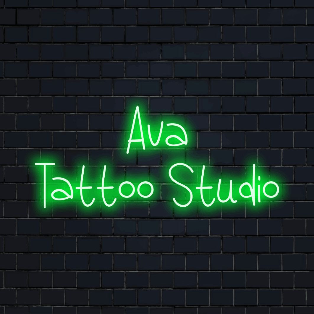 Ava Tattoo Studio Custom Name Neon Sign, bright neon glow against black brick wall