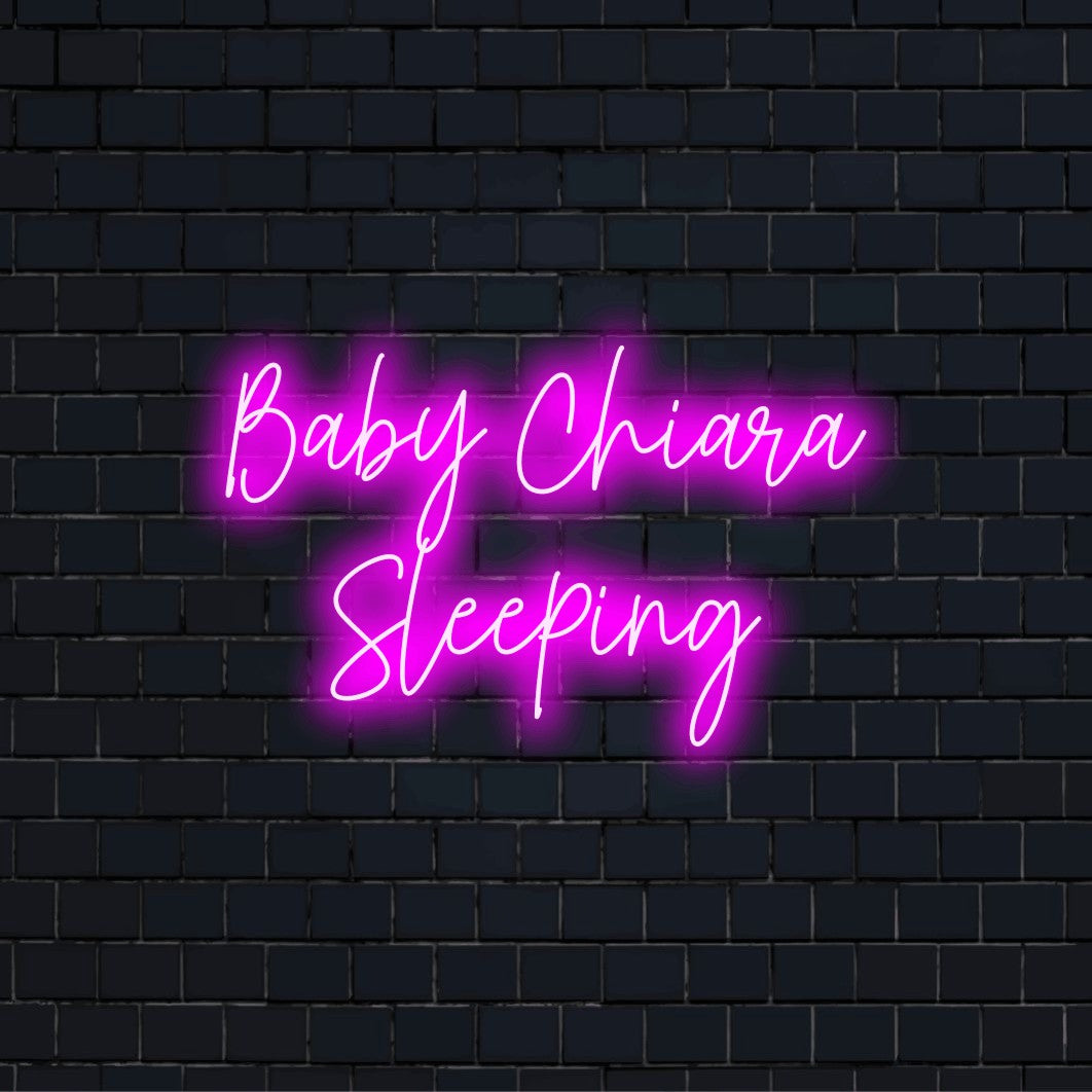 Baby Chiara Sleeping Personalized Neon Light with bright neon glow against brick backdrop