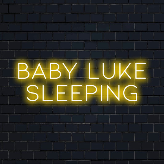 Baby Luke Sleeping Personalized Neon Light with bright neon lettering on dark brick wall
