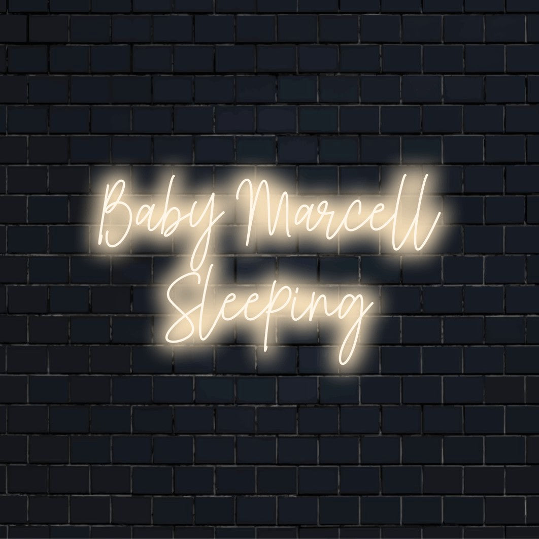 Baby Marcell Sleeping Personalized Neon Light with neon text light against black brick wall