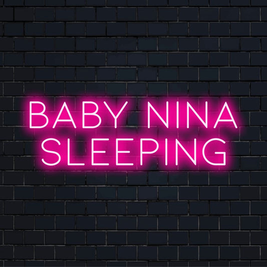 Baby Nina Sleeping Custom Name Neon Sign, neon text light against black brick wall