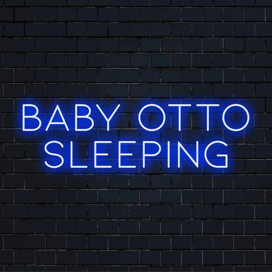 Baby Otto Sleeping Personalized Neon Light with glowing neon text against brick backdrop