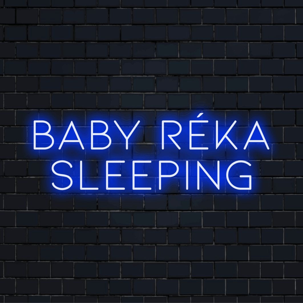 Baby Reka Sleeping Personalized Neon Light with bright neon glow against brick backdrop