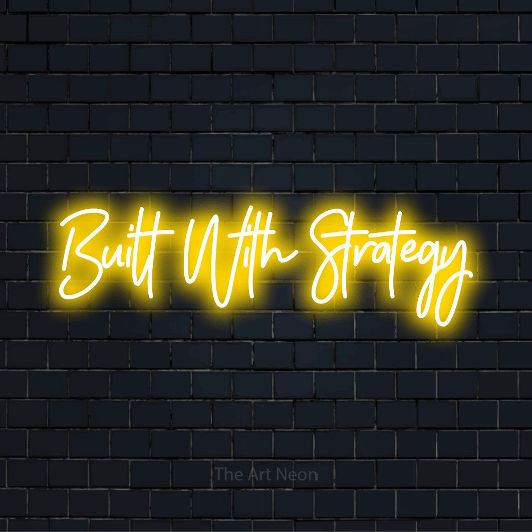"Built With Strategy" script-style LED neon sign on a black brick wall
