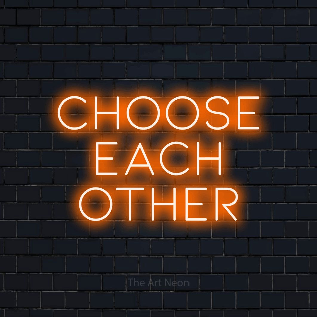 "Choose Each Other" script-style LED neon sign on a black brick wall