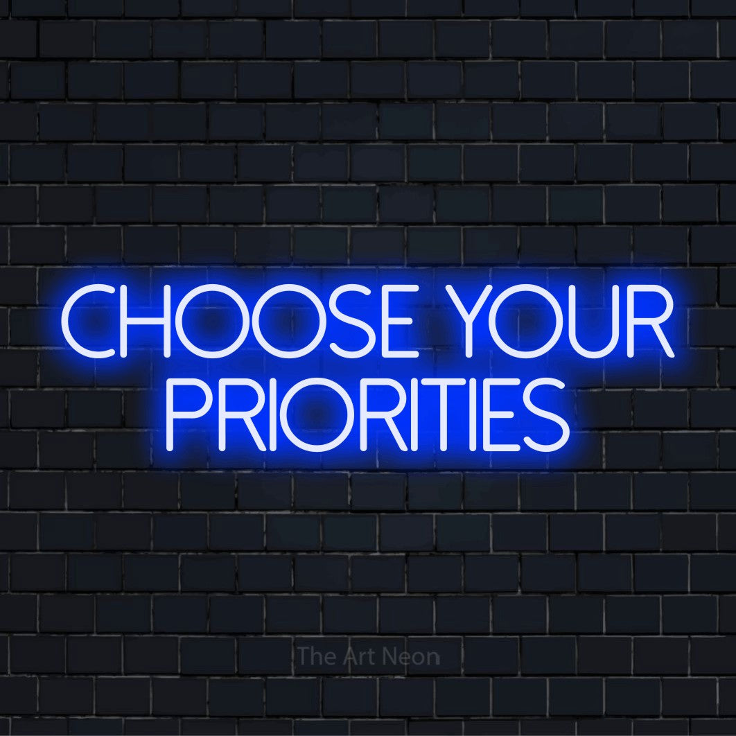 "Choose Your Priorities" LED neon sign on a black brick wall