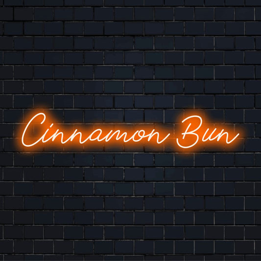 Cinnamon Bun Neon Sign, glowing lettering on black brick background
