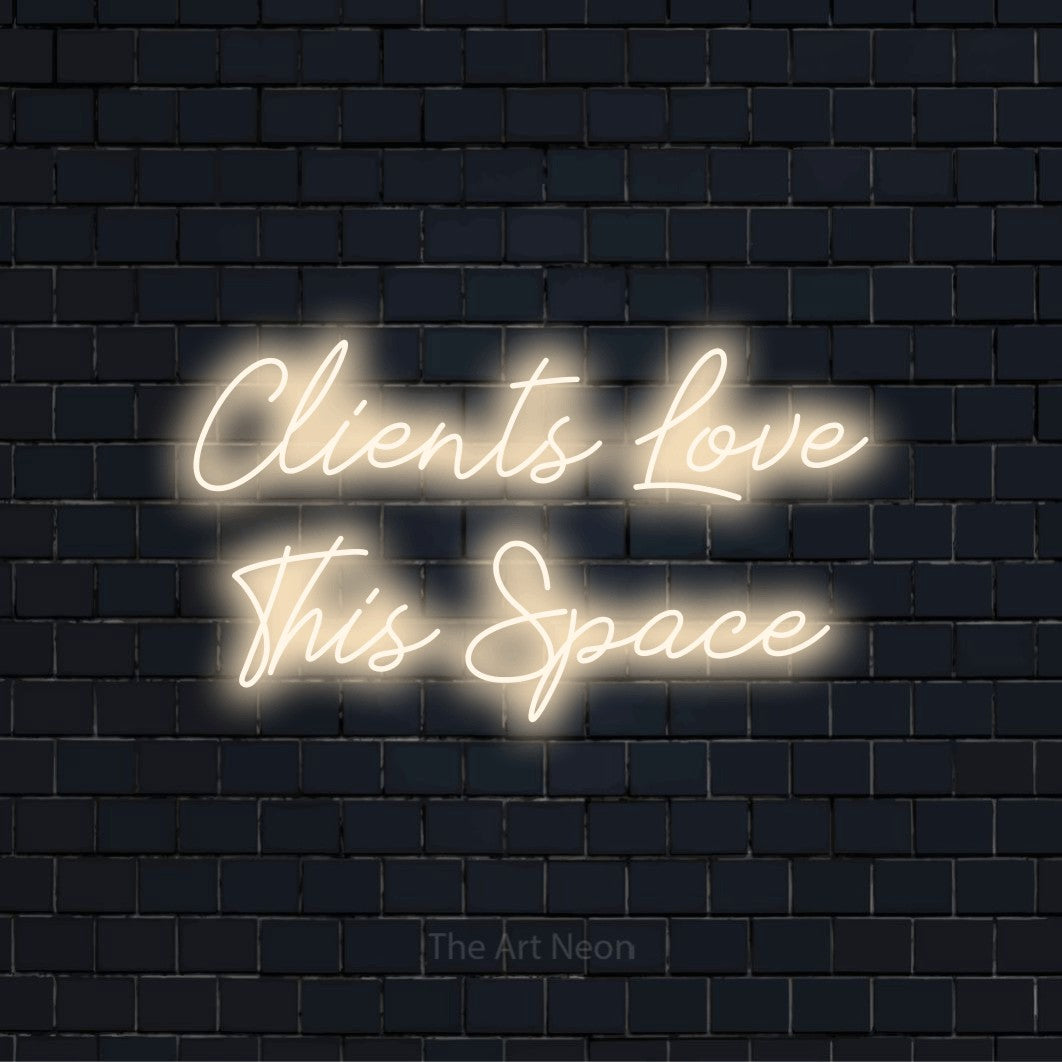 "Clients Love This Space" LED neon sign on a black brick wall