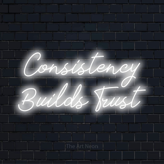 "Consistency Builds Trust" glowing LED neon sign on a black brick wall