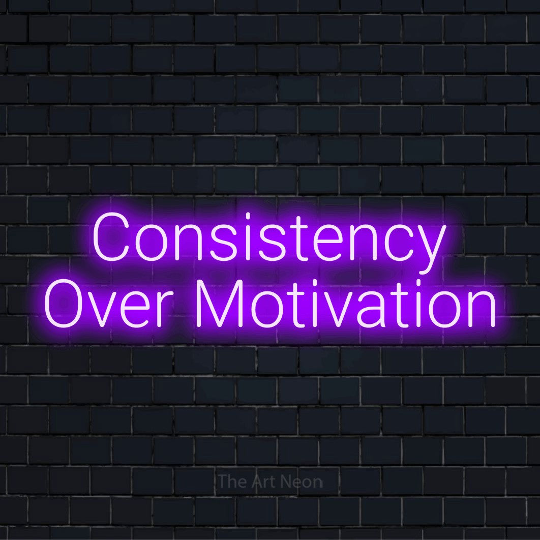"Consistency Over Motivation" neon text design on a black brick wall