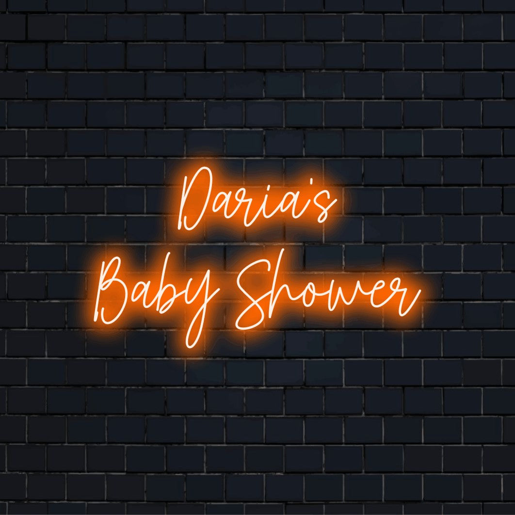 Daria_s Baby Shower Personalized LED Neon Sign, glowing lettering against black brick wall