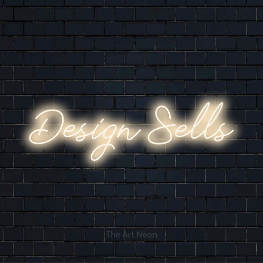 "Design Sells" neon text design on a black brick wall