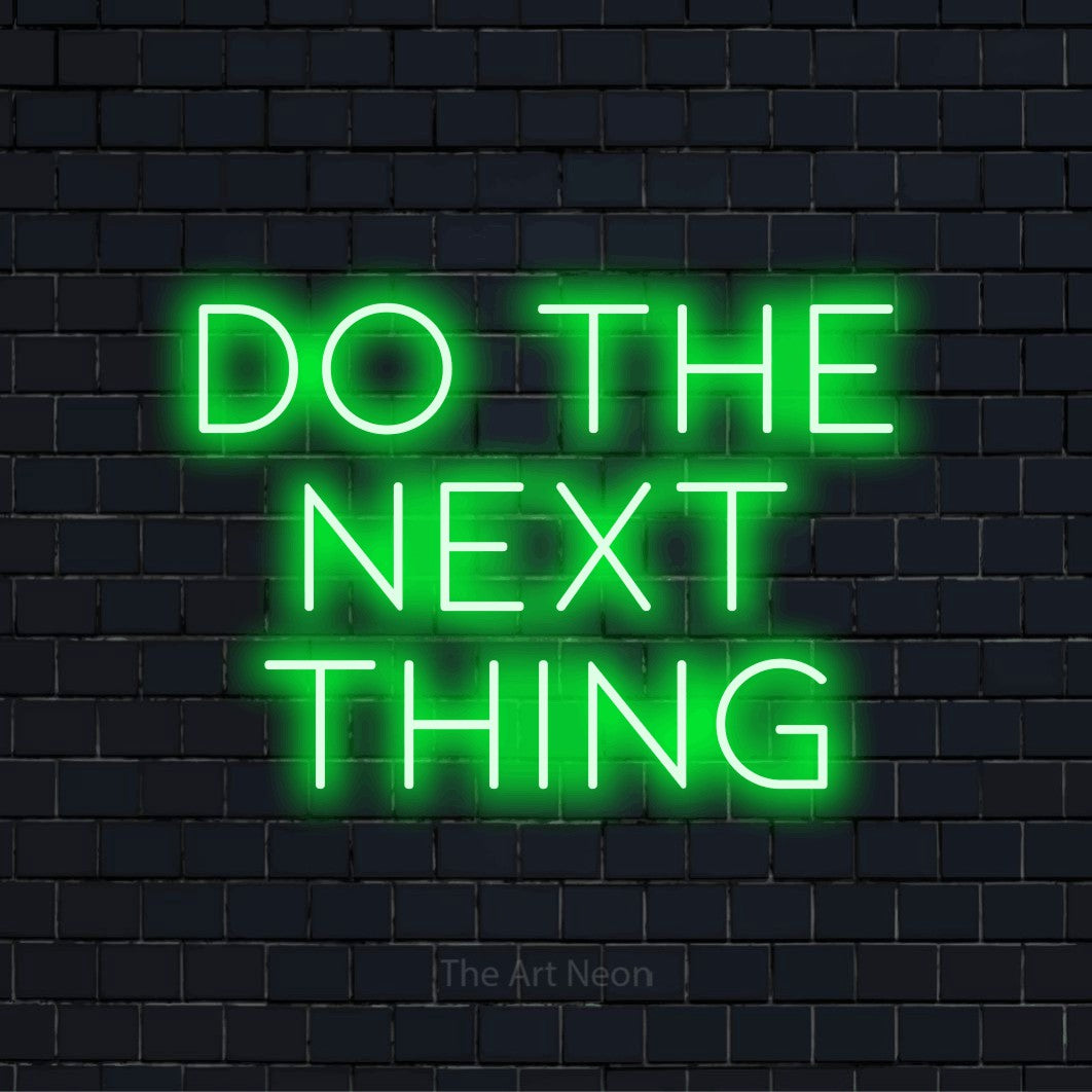 "Do The Next Thing" glowing LED neon sign on a black brick wall