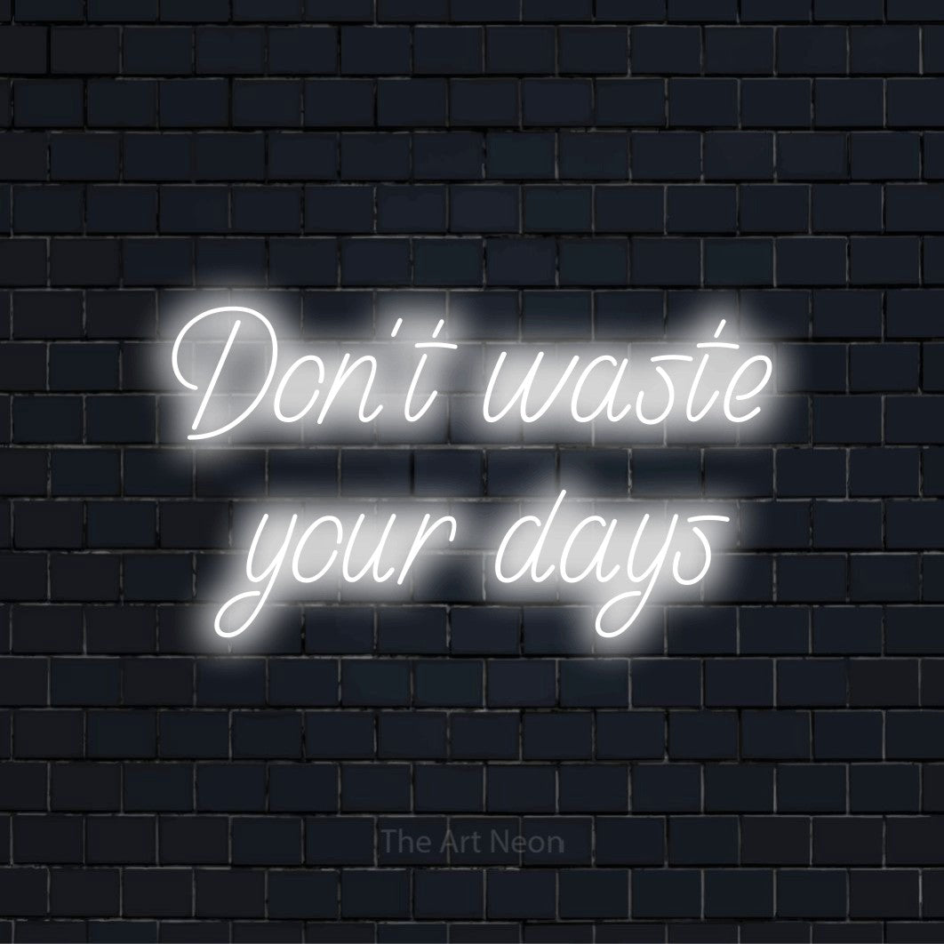 "Don’t Waste Your Days" script-style LED neon sign on a black brick wall