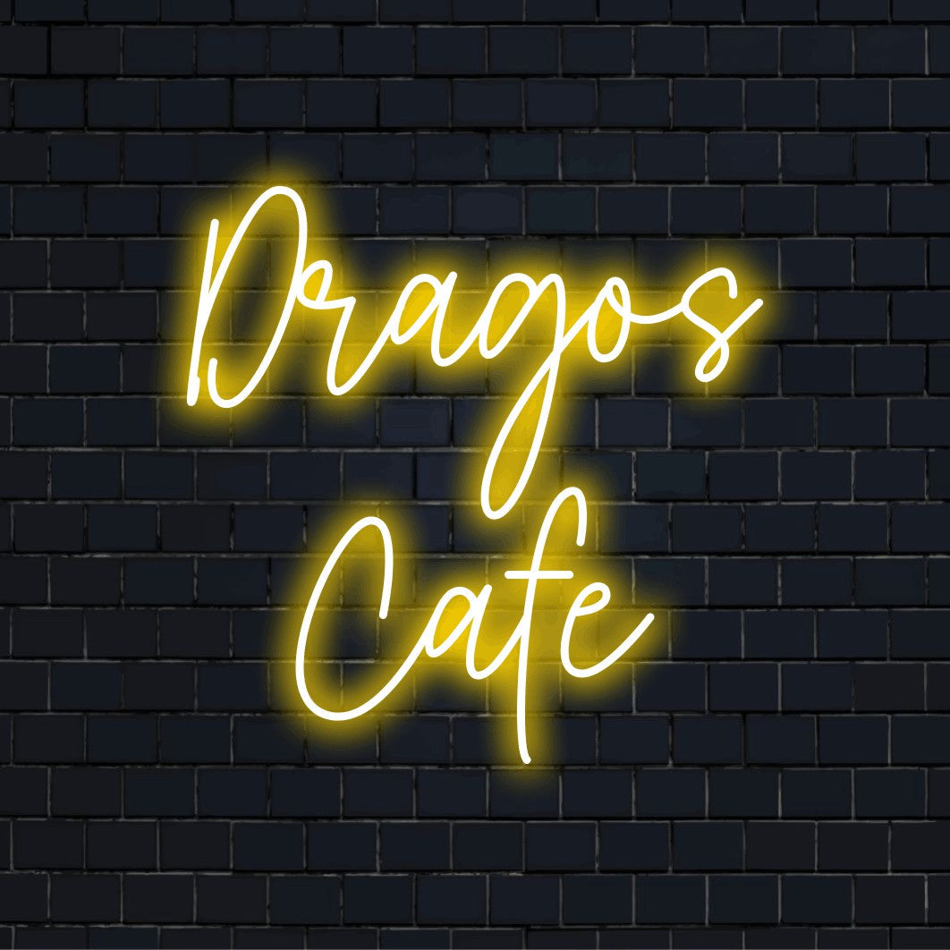 Dragos Cafe Personalized Neon Light with glowing lettering against black brick wall