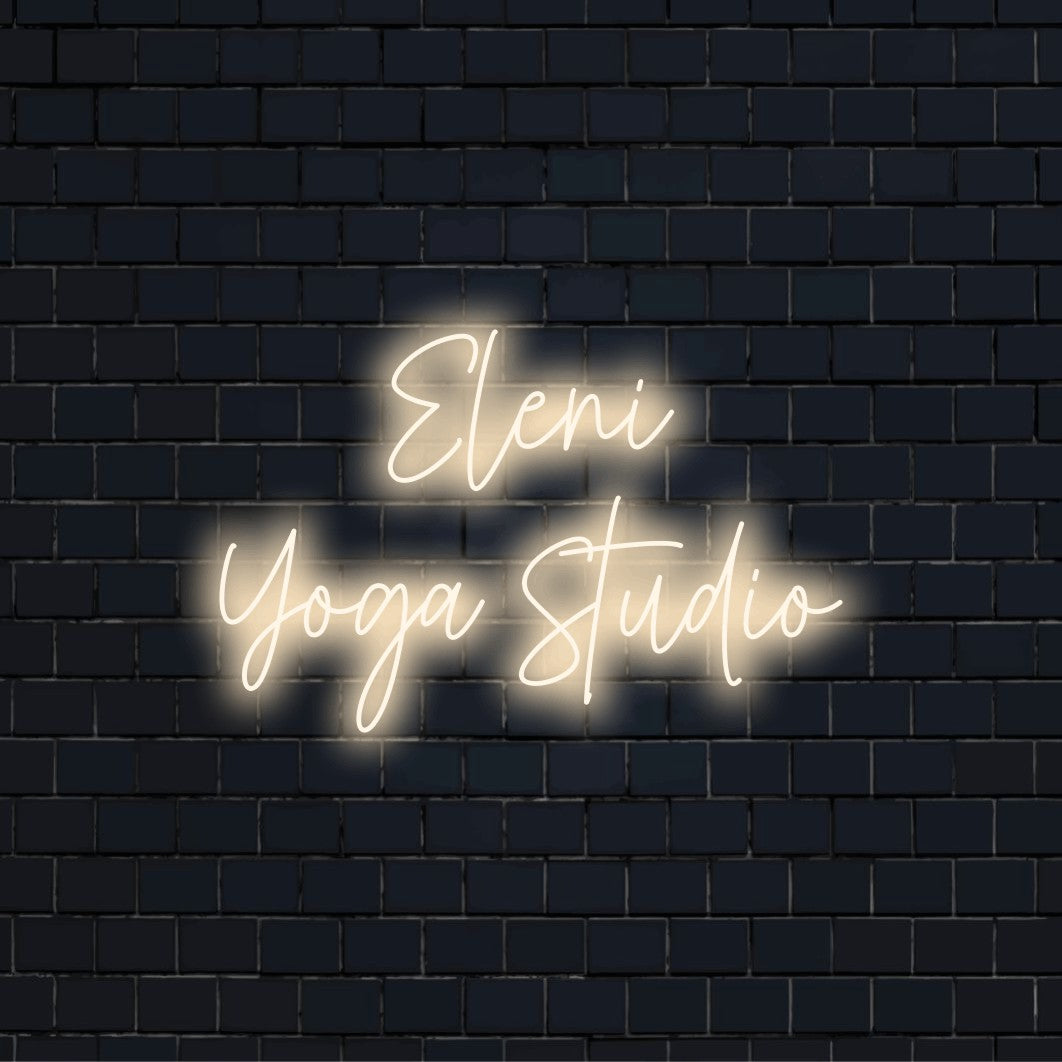 Eleni Yoga Studio Custom Name Neon Sign, glowing neon text against black brick wall