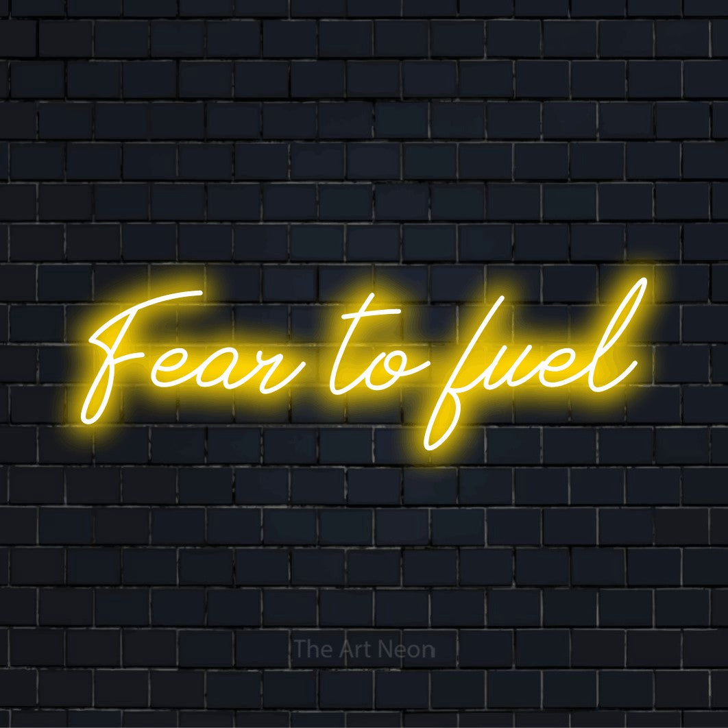 "Fear To Fuel" glowing LED neon sign on a black brick wall