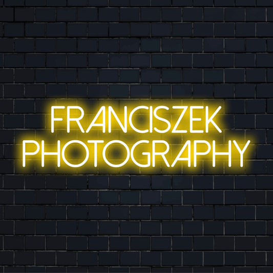 Franciszek Photography Custom Name Neon Sign, glowing lettering on dark brick background