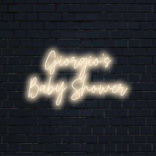 Giorgio_s Baby Shower Custom Name Neon Sign, glowing wall decor against brick backdrop
