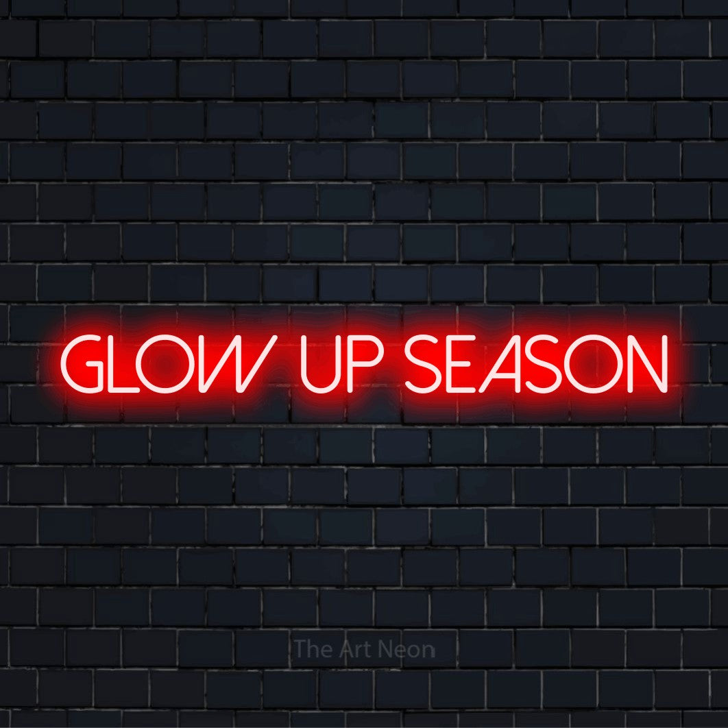 "Glow Up Season" glowing LED neon sign on a black brick wall