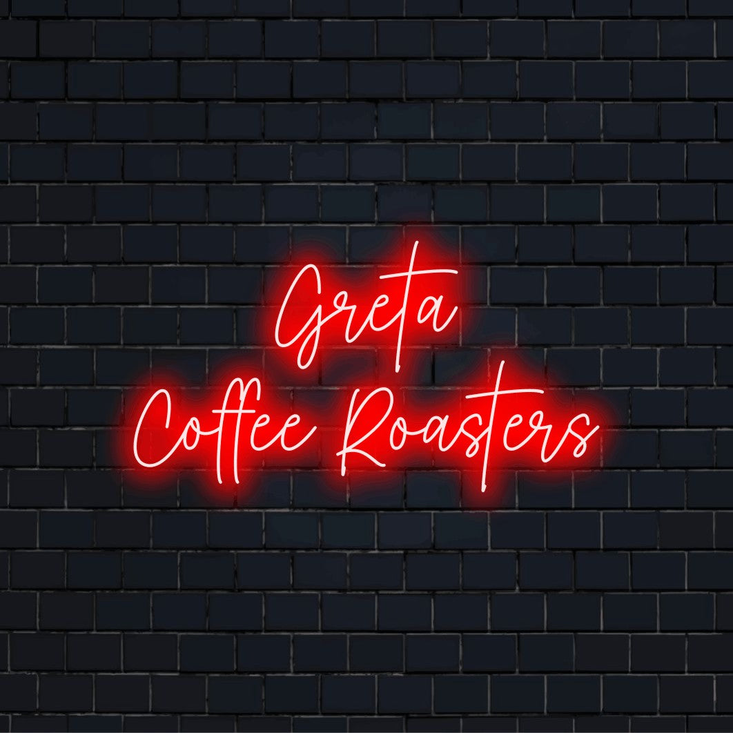 Greta Coffee Roasters Custom Name Neon Sign, glowing wall decor against brick backdrop