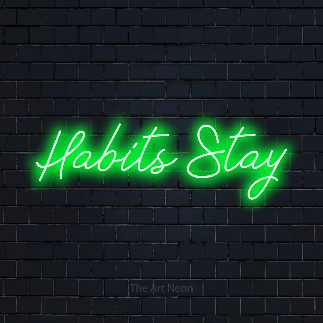 "Habits Stay" LED neon sign on a black brick wall