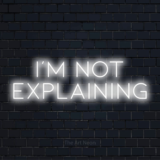 "I’m Not Explaining" neon text design on a black brick wall