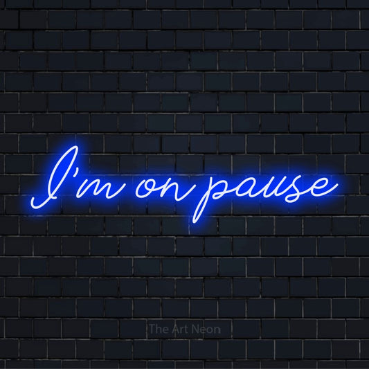 "I’m On Pause" script-style LED neon sign on a black brick wall