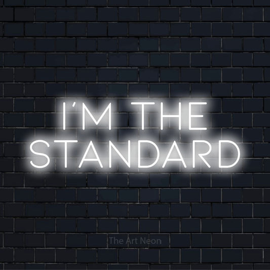 "I’m The Standard" neon text design on a black brick wall