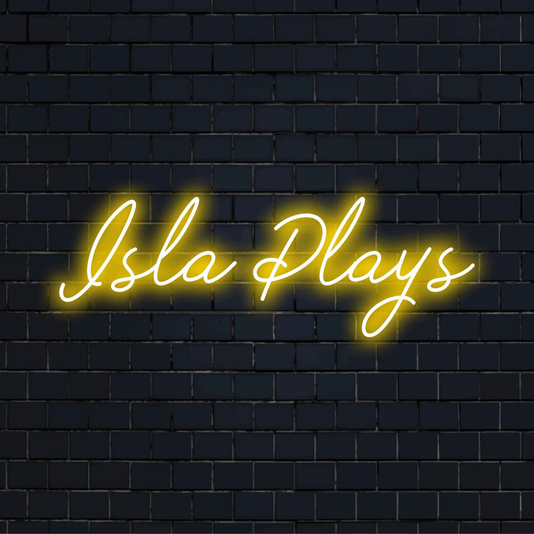 Isla Plays Personalized Neon Light with glowing wall decor against black brick wall
