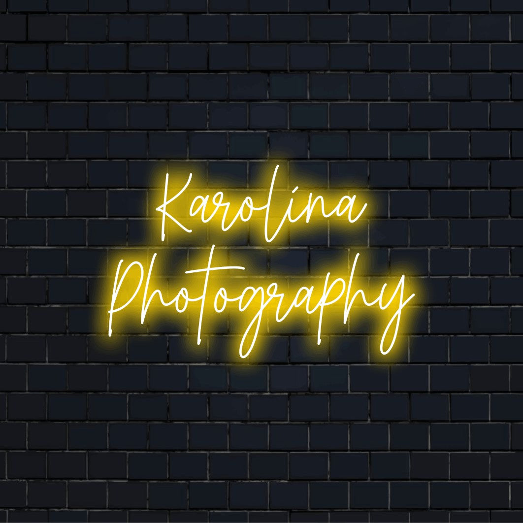 Karolina Photography Personalized Neon Light with bright neon lettering against black brick wall