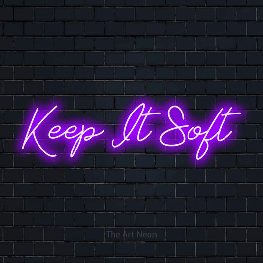 "Keep It Soft" neon text design on a black brick wall