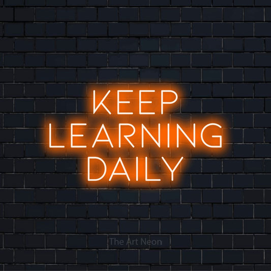 "Keep Learning Daily" glowing LED neon sign on a black brick wall
