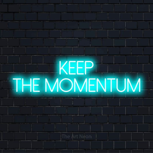 "Keep The Momentum" glowing LED neon sign on a black brick wall
