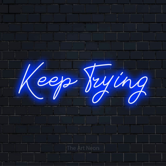 "Keep Trying" text design with neon effect on a black brick wall