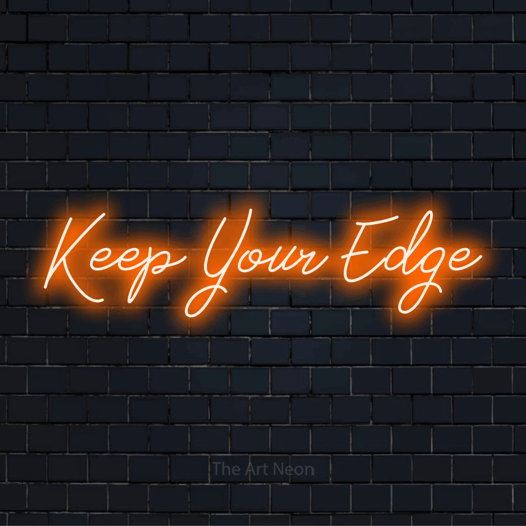 "Keep Your Edge" script-style LED neon sign on a black brick wall