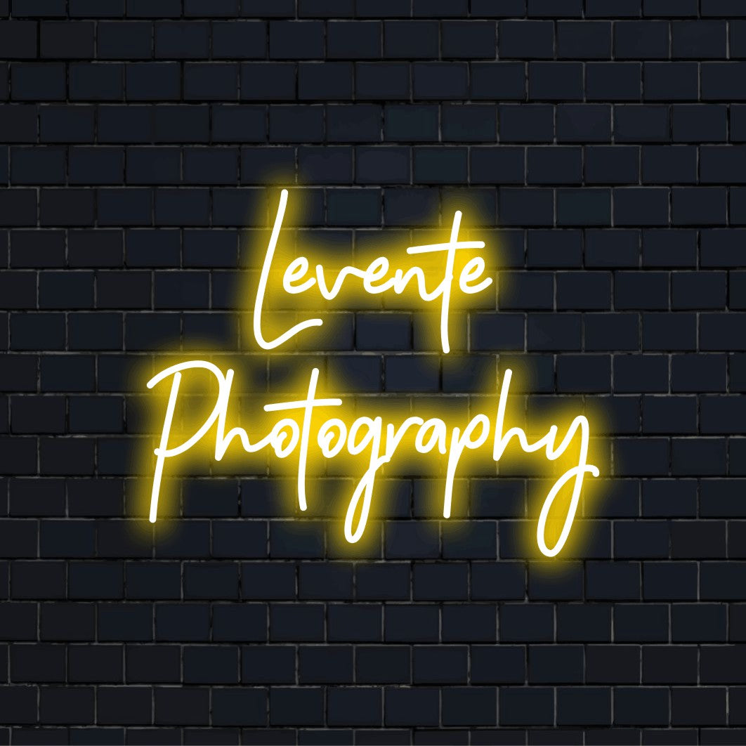 Levente Photography Personalized LED Neon Sign, glowing lettering against black brick wall