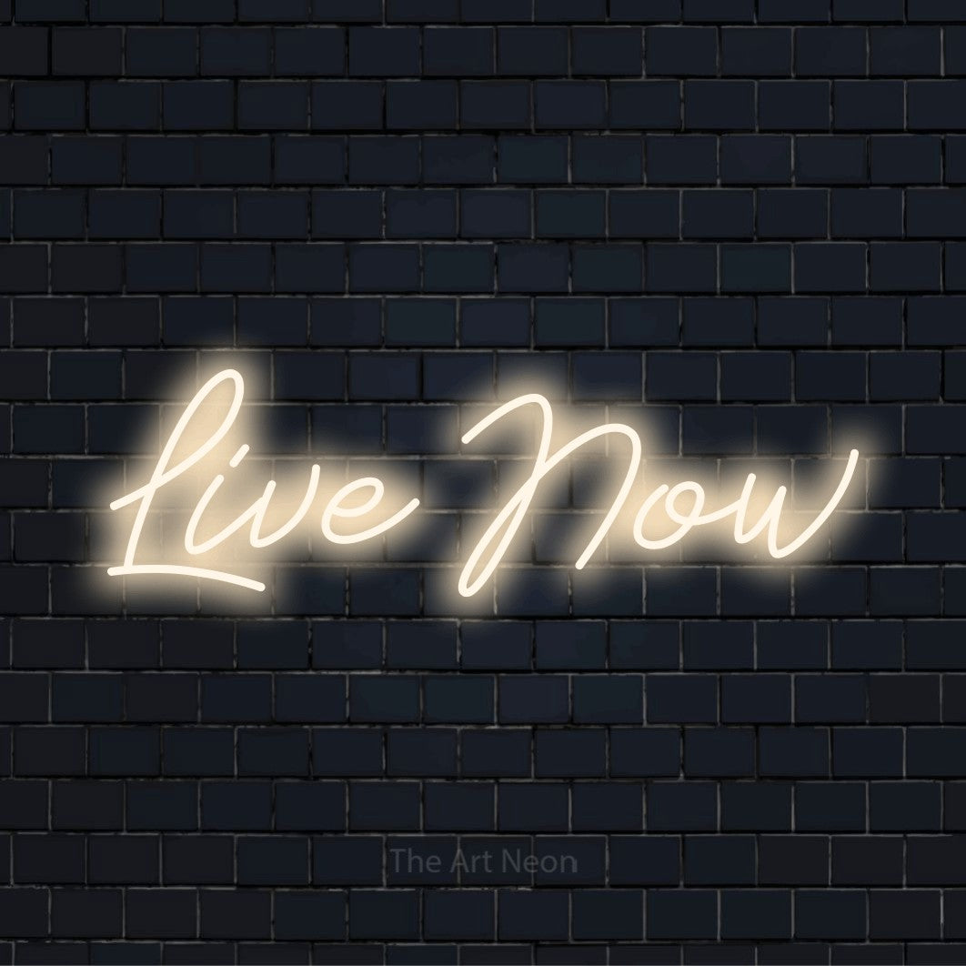 "Live Now" script-style LED neon sign on a black brick wall