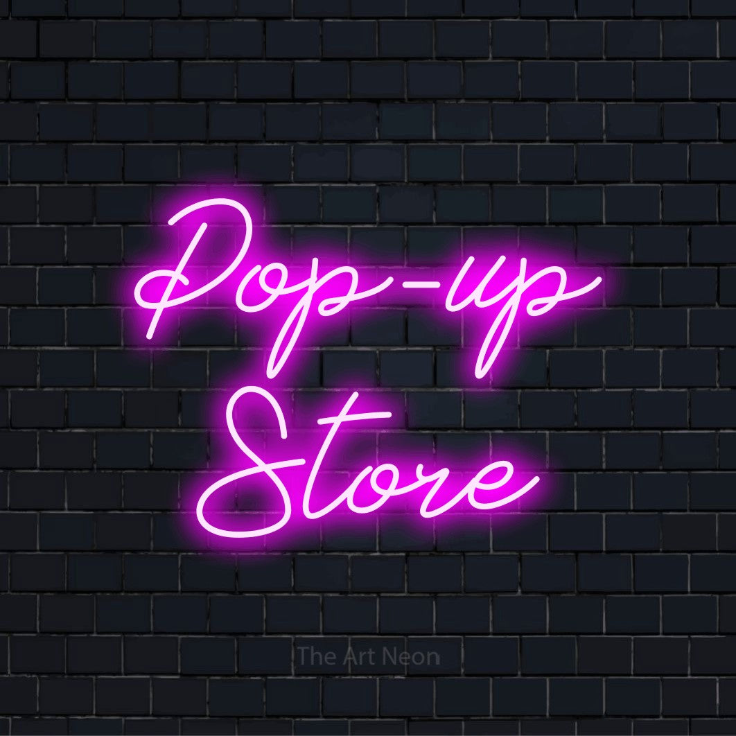 LED-Neonschild mit dem Design „Pop-up Store“ auf dunkler Ziegelwand
