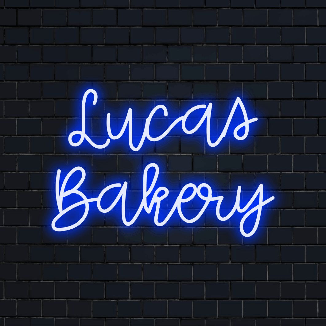 Lucas Bakery Custom Name Neon Sign, bright neon glow against black brick wall