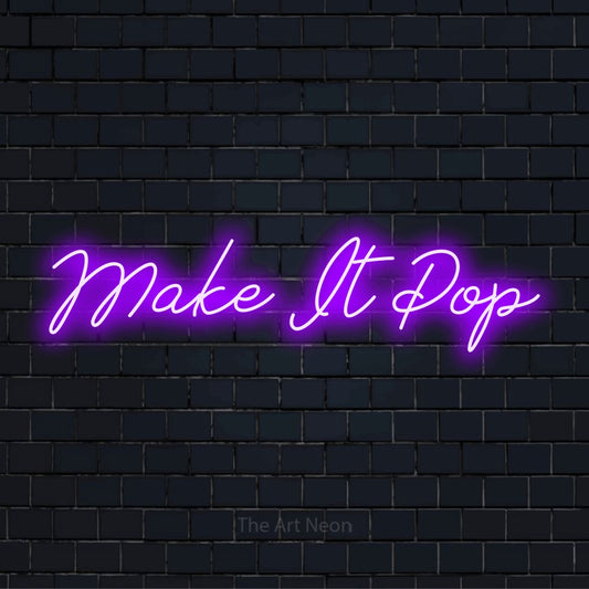 "Make It Pop" neon text design on a black brick wall
